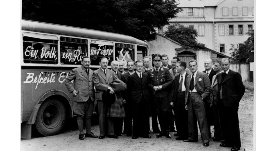 ''Befreite Elsäßer danken Adolf Hitler!'' - Die von der deutschen Wehrmacht befreiten ''Nanziger'' am Bus, der sie nach Straßburg bringen sollte: René Schlegel rechts neben Oberstadtkommissar Robert Ernst. Trois-Épis 1940. Fotografie: archives.strasbourg.eu